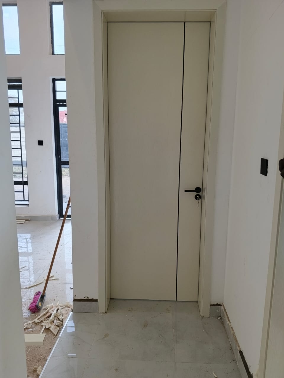 White flush door with black handle, installed