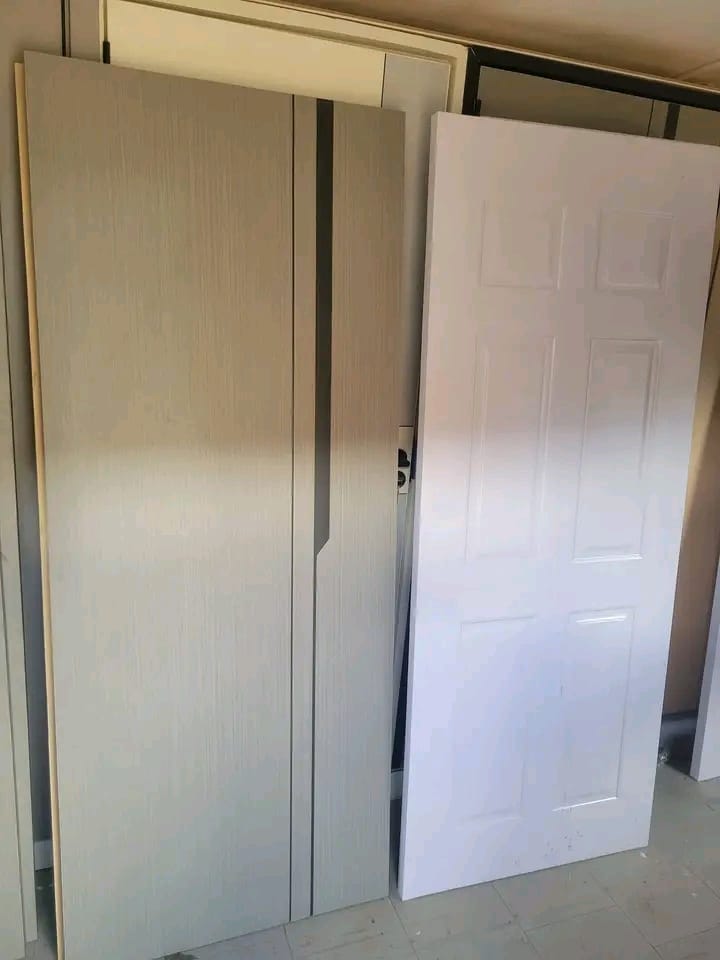White moulded panel door next to a grey flush door