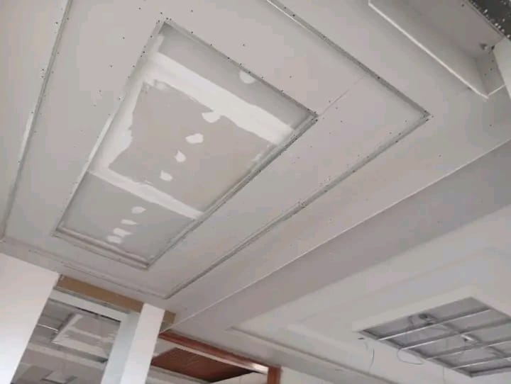 Gypsum board ceiling installation in progress, boards and joints visible